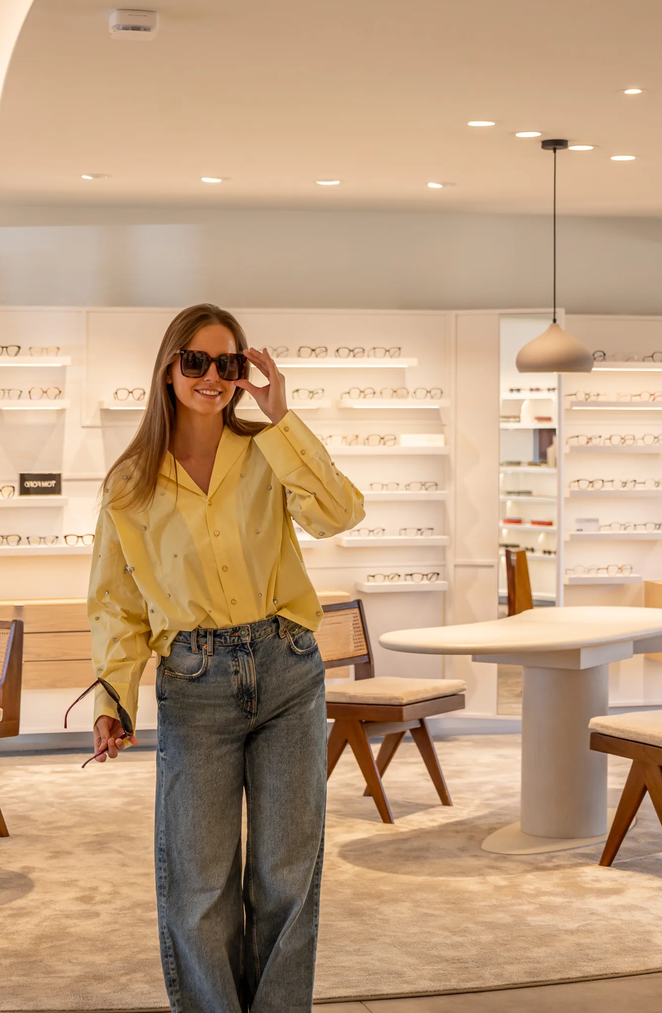 Anaïs past lachend een zonnebril in de winkel van An-Eyes
